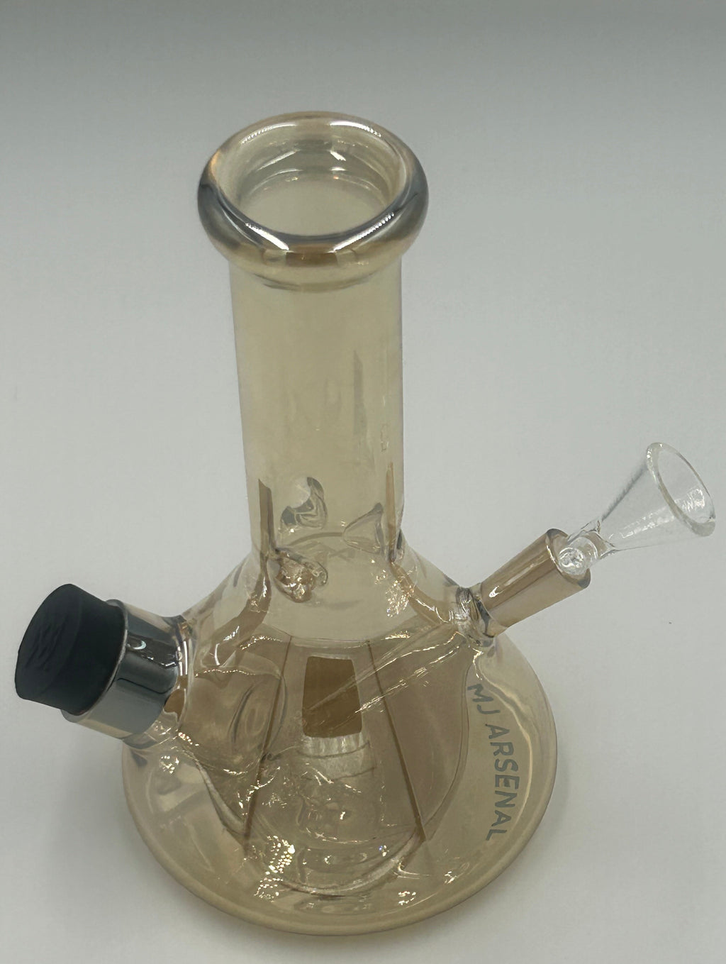 A clear glass wall-mounted water pipe with a cylindrical neck, angled bowl, and a circular backplate engraved with 'MJ ARSENAL'.
