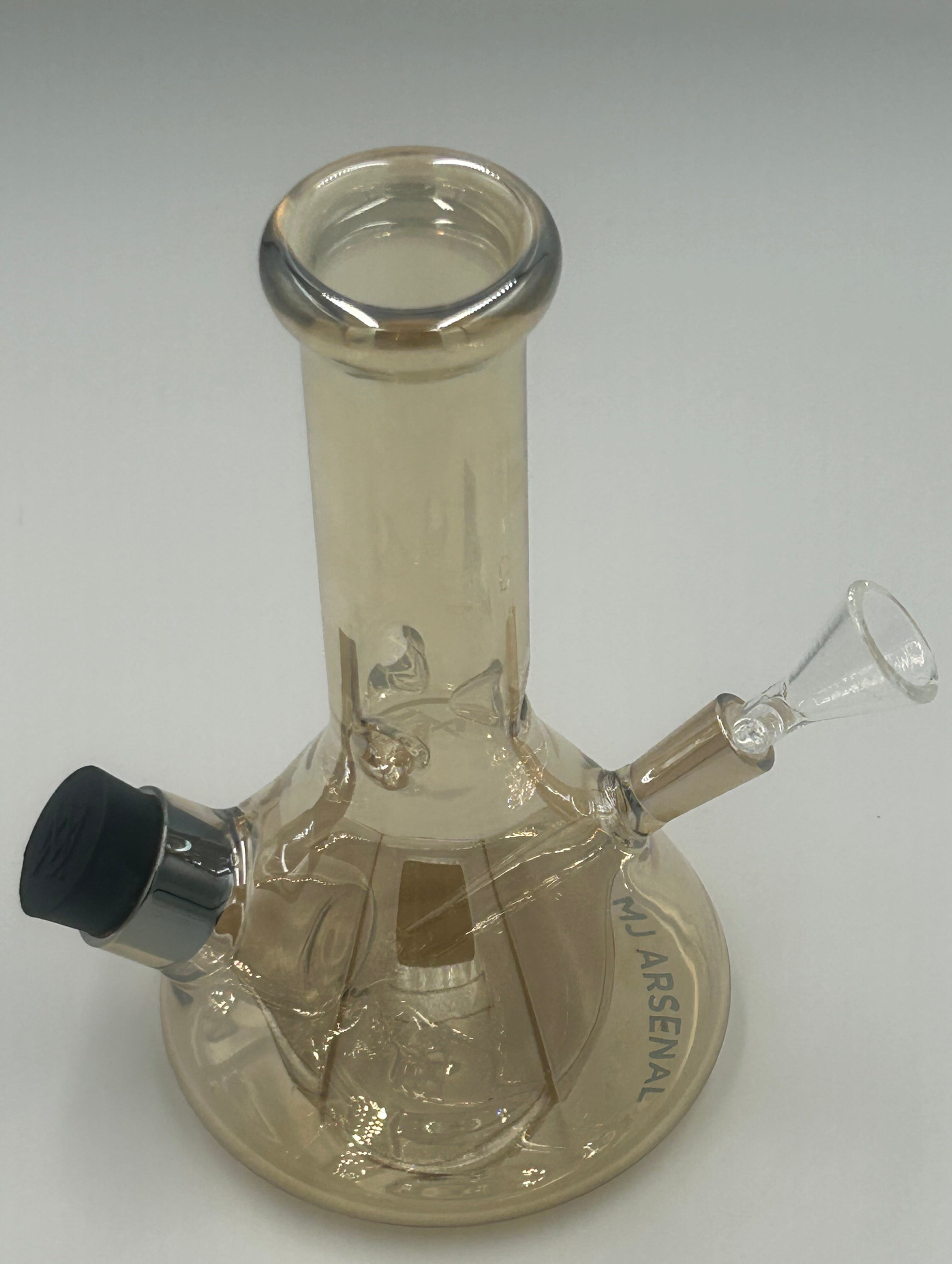 A clear glass wall-mounted water pipe with a cylindrical neck, angled bowl, and a circular backplate engraved with 'MJ ARSENAL'.