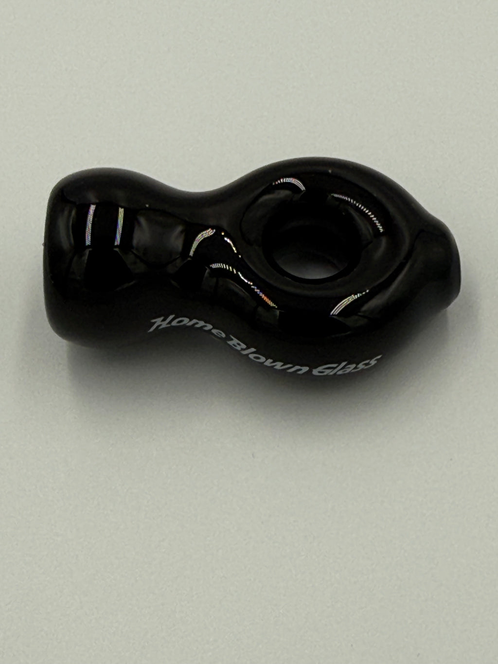 A black glass adult novelty product with a textured, organic shape and white script text reading 'Home Blown Club' on its side, photographed on a neutral light gray background.