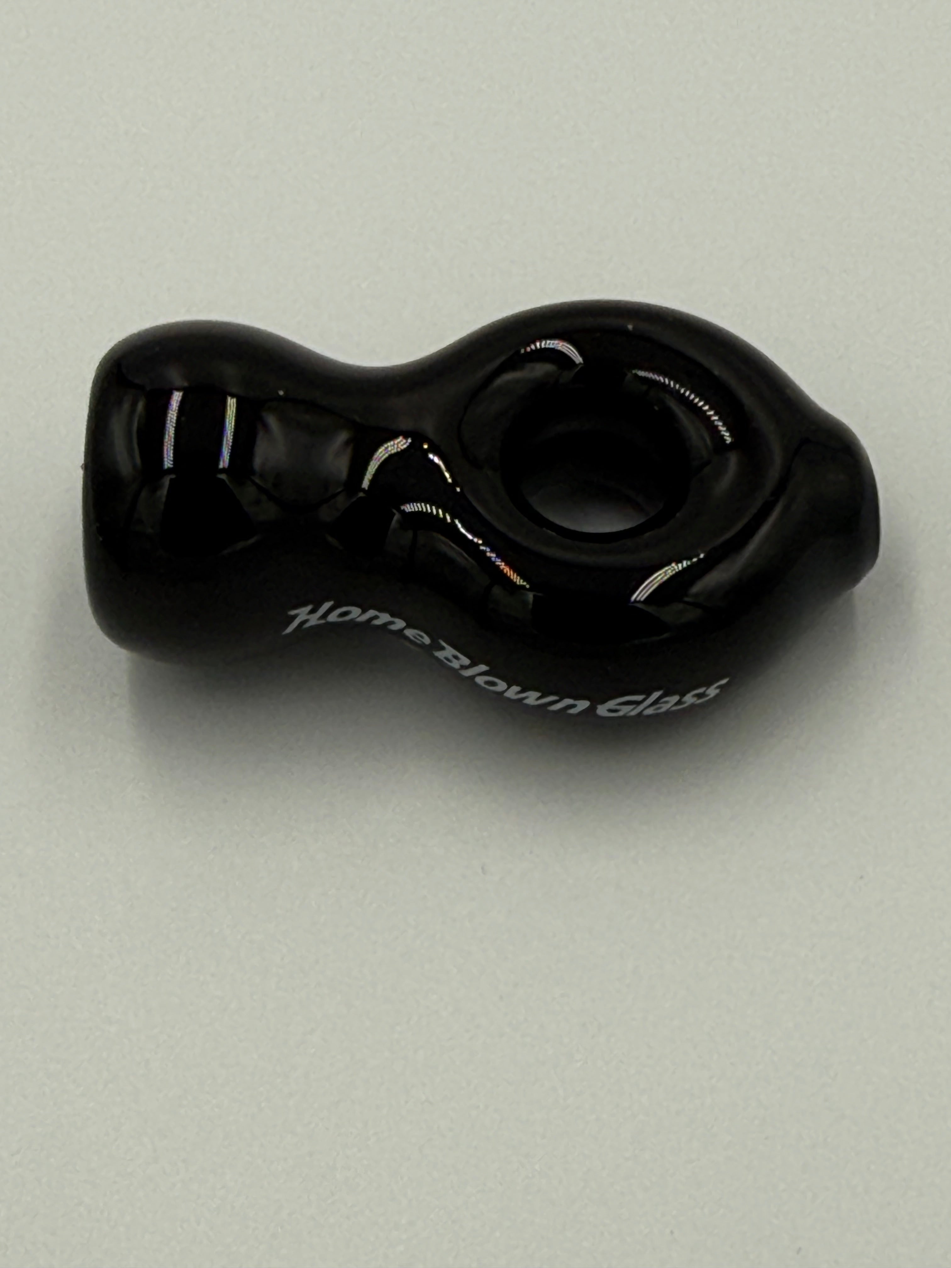 A black glass adult novelty product with a textured, organic shape and white script text reading 'Home Blown Club' on its side, photographed on a neutral light gray background.