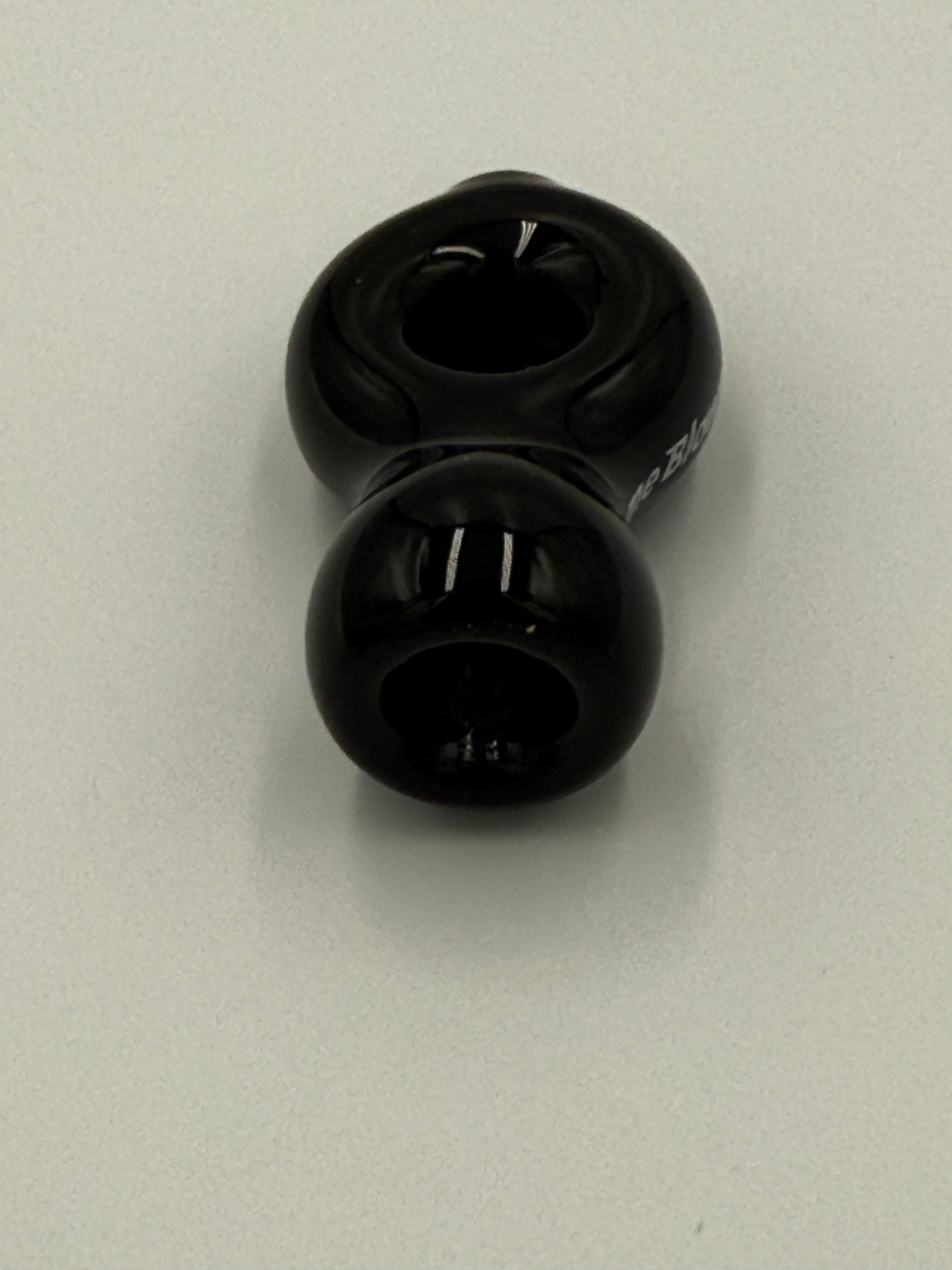 Two black plastic ball bearing cups on a light gray background.